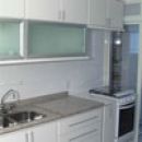 Cozinha em MDF branco com portas basculantes em perfil de alumnio e vidro